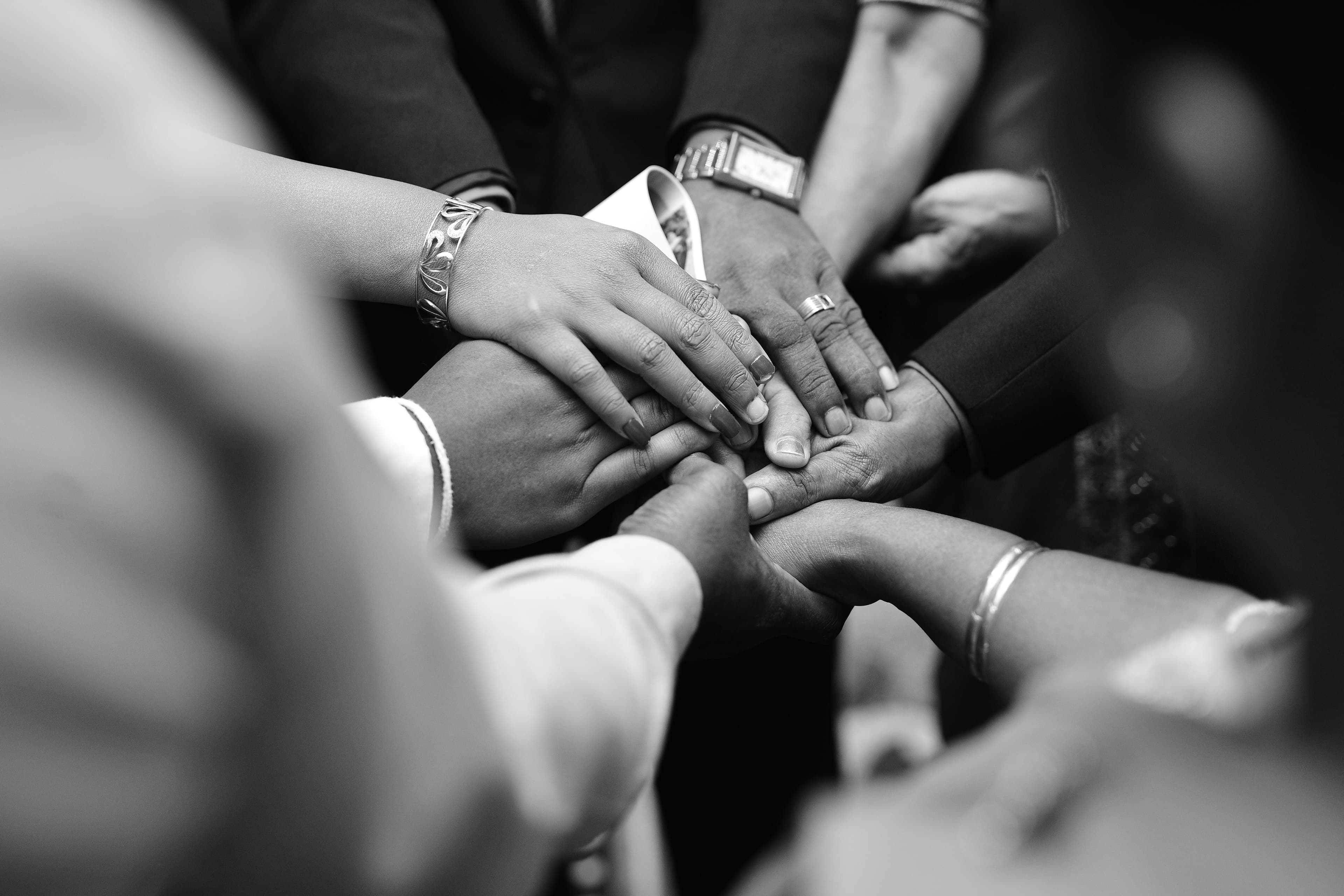 A diverse group joining hands in a shared commitment to work together